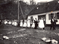 Svatební průvod před stavením Bradáčových, odkud rodinu v roce 1951 deportovali, svatba Václava a Marie Bradáčových, Gerník, 1969