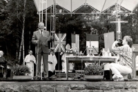 The first commemorative gathering in 1990 on the anniversary of the burning of the village of Ležáky. Actor Radovan Lukavský speaks on stage