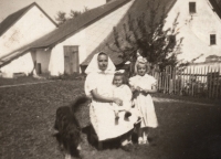 Ludmila Poláchová's sister on the right, next to her sitting neighbour , a Romanian Slovak from Valterice. In the background the house of the Martinat family in Valterice, 1946