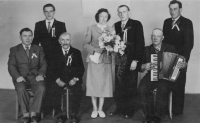 The extended family, father with the accordion that his mother got for the bread she took to the German prisoners