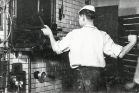 Baker apprentice Arnošt Obrusník in 1954 while putting bread into the oven