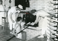 Putting cakes into the oven in the bakery in Dolní Benešov. Emil Čekala with a hat on the left, Mr. Verner standing with a shovel at the bottom, Mr. Adamík on the right, 1980s