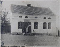 Rodinný obchod s smíšeným zbožím ve Svinařích, 1930 (Na fotografii je pravděpodobně pamětníkova babička Boučková a chlapci jsou náhodní zákazníci, ale babičkou ani chlapci si pamětník není jist.)