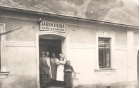 Pohled na řeznictví matčina otce Jakuba Fajky na (dnešní) Podolské ulici. Podle popisku na fotografii osoby zleva. 1. neznámá, 2. Františka Fajková, 3. Paulina – sestra Jakuba Fajky, 4. syn Jakuba Fajky František, 5. Josef – čeledín. Fotografie někdy z 20. - 30. let dvacátého století