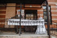 Wedding photo with the poster "For our and your freedom" on the background of the editorial office of the newspaper "Provincie Pskov", Pskov, 2018