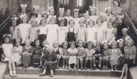 Stanislava in the first class of the municipal school in Holešov, on the photo standing in front of the teacher between two girls, 1941